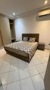 a bedroom with a large bed in a room at Residence Golden Beach in Bin Rhilouf