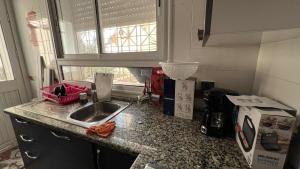 a kitchen counter with a sink and a window at Residence Golden Beach au bord de la mer in Bin Rhilouf