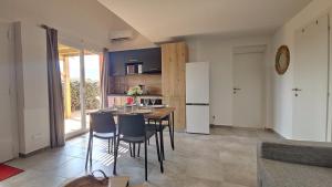 una cucina con tavolo, sedie e frigorifero di Casa Fadiju a Lecci