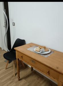 a wooden table with a plate of food on it at Room private Ossi in Ossi