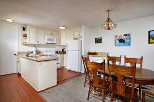 una cucina con un tavolo e un frigorifero bianco di Oceanside Beach Condos a Oceanside