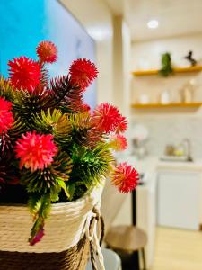 a basket filled with red flowers on a table at Chic 1-Bedroom Hideaway in Ligao City, Albay in Tuburan
