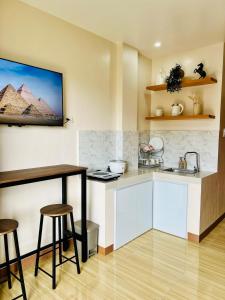 a kitchen with a sink and a counter with stools at Chic 1-Bedroom Hideaway in Ligao City, Albay in Tuburan +10 photos