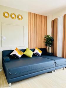 a blue couch with pillows on it in a living room at Chic 1-Bedroom Hideaway in Ligao City, Albay in Tuburan