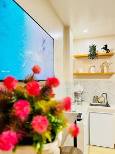 a kitchen with a vase of flowers on a table at Chic 1-Bedroom Hideaway in Ligao City, Albay in Tuburan