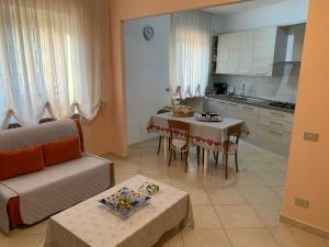 a living room with a couch and a table in a kitchen at Lux Appartamento in Busso