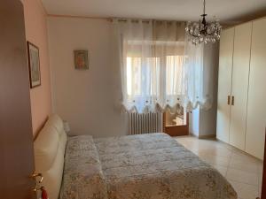 a bedroom with a bed and a chandelier at Lux Appartamento in Busso