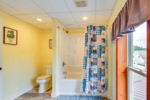 e bagno con vasca, servizi igienici e tenda per la doccia. di Renovated 1800s Brick Farmhouse in Granville a Granville Altre 29 foto