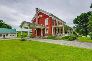 una casa in mattoni rossi con un cortile verde di Renovated 1800s Brick Farmhouse in Granville a Granville