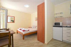 a small room with a bed and a kitchen at Apartments Begovic in Savina +83 photos