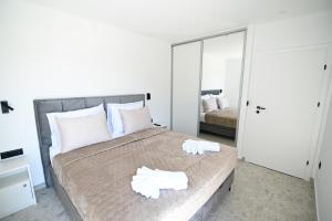 a bedroom with a large bed with two towels on it at Villa Matea pool house in Zadar +24 photos
