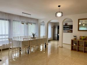 a dining room with a white table and chairs at Casa Zena Predeluț in Predeluţ