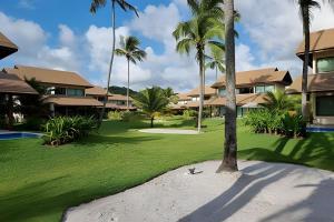 ein Resorthof mit Palmen und Häusern in der Unterkunft Bangalô Essenza do Sol |Luxo & Charme em Carneiros in Tamandaré