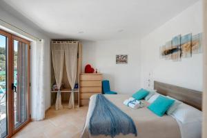 a bedroom with a large bed with blue pillows at Cynara holiday house in Massa Lubrense