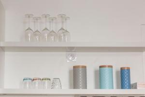 a shelf filled with glass bottles and vases at L'escale - Centre ville - 3 étoiles in Bourg-en-Bresse +12 photos