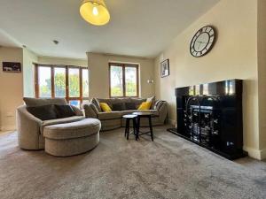 a living room with two couches and a clock above a fireplace at My Kilkenny Stay - walk to city centre in 5 mins in Kilkenny