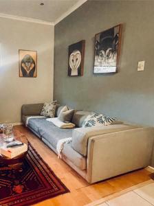 a living room with a couch and a bed at Milnerton Cottage in Cape Town