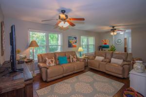 a living room with two couches and a ceiling fan at 838 Fiddlers Ridge in Fripp Island