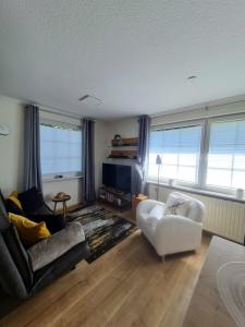 a living room with a couch and a chair at DAS kleine Haus in Wandlitz