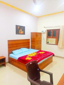 a bedroom with a bed with a red blanket on it at Shri radha rani dham in Vrindāvan