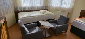 Cette petite chambre comprend un lit et deux chaises. dans l'établissement Apartment Siofok, Lake Balaton 4, à Siófok