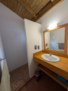 ein Badezimmer mit Waschbecken und Spiegel in der Unterkunft Villa dans un have de paix avec piscine in Saint-François + 7 Fotos