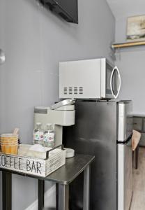 a kitchen with a table with a microwave and a refrigerator at Washington Park Motel Standard Suite in Norwell