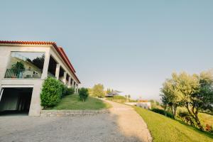 a house with a driveway next to a building at Encosta do Sol in Abadim