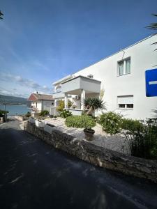 a white building with a road in front of it at Adriatic Breeze Family Stay in Trogir