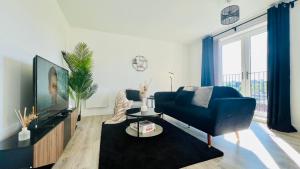 a living room with a blue couch and a tv at Entire Luxury 2 Bedroom Apartment - Quiet & Central with Free Parking in Birmingham