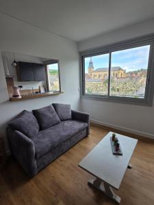 a living room with a couch and a table at le cocon sarladais, appartement centre ville avec balcon et parking privé in Sarlat-la-Canéda