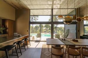 eine Küche und ein Esszimmer mit Tisch und Stühlen in der Unterkunft MAISON CHAPRON Villa de standing avec piscine, calme et golf à Biscarrosse in Biscarrosse