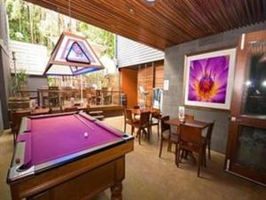 a room with a pool table and a dining room at Global Backpackers Port Douglas in Port Douglas