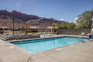a swimming pool with a mountain in the background at Rim Village A1 in Moab