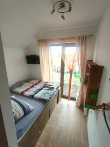 a bedroom with a bed and a large window at House Seaside Relaxation - Nadmorski Relaks do 10 osób in Sarbinowo