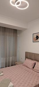 a bedroom with a bed with a pink comforter at South Side Apartment in Podgorica +14 photos