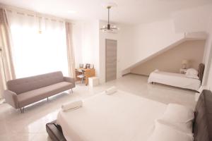 a white living room with a couch and a bed at Dreams on the Blue house 1 in Valderice