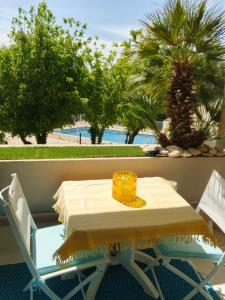 a table and chairs on a balcony with palm trees at T2 loggia et piscine in La Rochelle