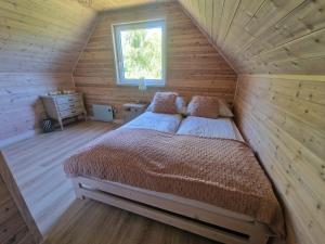 NiepoczołowiceDomek pod lasem的木屋里有一张床的卧室