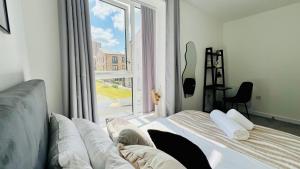 a bedroom with a bed and a large window at Entire Luxury 2 Bedroom Apartment - Quiet & Central with Free Parking in Birmingham