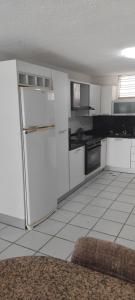 a kitchen with white cabinets and a refrigerator at Appartamento La Marina piano terra 3 stanze in Porlamar