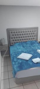 a bedroom with a bed with a blue comforter at Appartamento La Marina piano terra 3 stanze in Porlamar