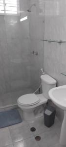 a white bathroom with a toilet and a sink at Appartamento La Marina piano terra 3 stanze in Porlamar +5 photos