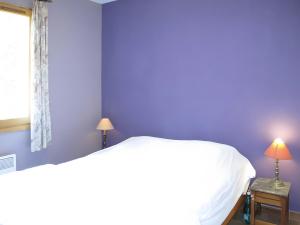 a bedroom with a white bed and a purple wall at La Bignone in Régusse +7 photos