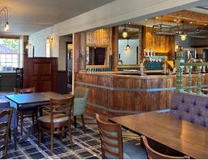 a restaurant with tables and chairs and a bar at The Bell Hotel Cottages in Burgh le Marsh