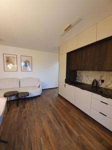 een woonkamer met een witte bank en een tafel bij Apartament Łynova z parkingiem podziemnym in Olsztyn