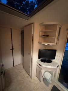 a small room with a tv on a table in an rv at Karavan Ždáň in Slapy