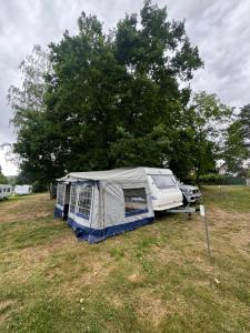 ein Zelt und ein Auto auf einem Feld in der Unterkunft Karavan Ždáň in Slapy nad Vltavou
