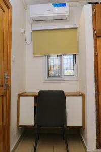 a desk with a chair in front of a window at 1 Bedroom Apartment in Douala +2 photos