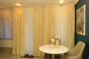 a table with flowers in vases on it in a room at 1 Bedroom Apartment in Douala